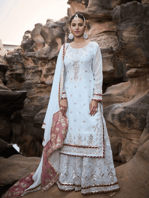 Elegant faux georgette top with thread, sequin, rivet moti, and fancy lace border details, paired with matching sharara and dupatta featuring similar embroidery and lace accents.