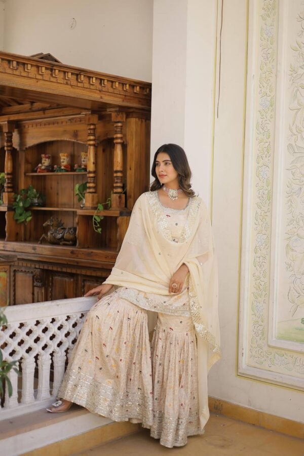 An elegant viscose jacquard gharara set featuring sequins and zari embroidery, a stylish round-neck kurti, and a Russian silk dupatta with embroidered lace. Available in Off-White, Rani-Pink, and Wine.