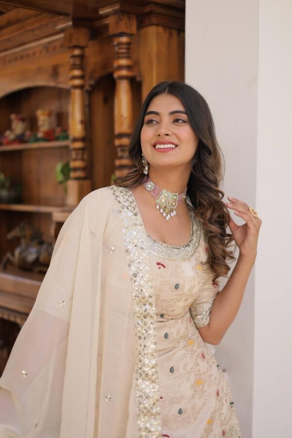 An elegant viscose jacquard gharara set featuring sequins and zari embroidery, a stylish round-neck kurti, and a Russian silk dupatta with embroidered lace. Available in Off-White, Rani-Pink, and Wine.