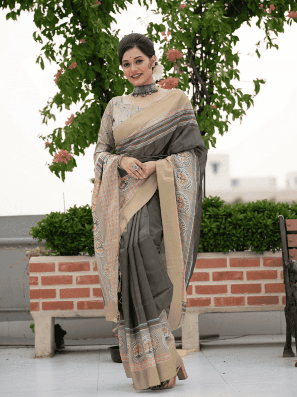 Tussar Print Soft Saree with a zari border, traditional Warli-printed pallu, a matching printed blouse, and fancy tassels for a graceful look.