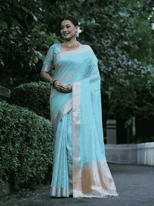 A graceful Maheshwari tissue silk saree adorned with zari woven butties, a rich zari pallu, and a beautifully designed border with fancy tassels. Includes a matching blouse piece.