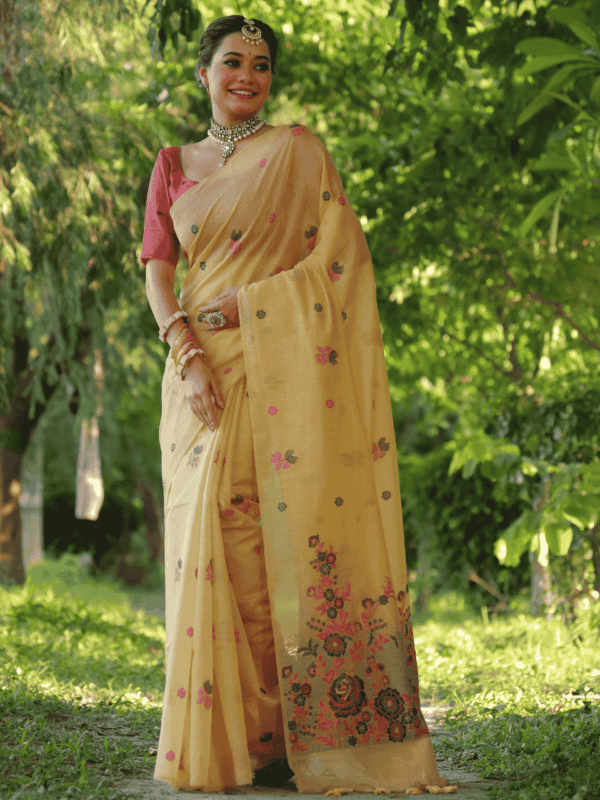 Luxurious cotton saree with intricate floral weaving, vibrant resham pallu, stylish tassels, and a complementing contrast blouse piece.