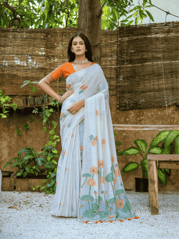 Exquisite soft silk saree with detailed floral weaving, a traditional Pichwai-style pallu, elegant tassels, and a stylish contrast blouse piece.