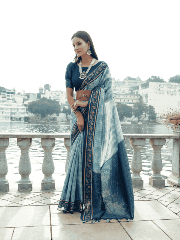 Soft silk saree with a floral-printed contrast border, an intricately woven zari pallu, and an elegant all-over zari weaving pattern, paired with a matching contrast blouse.