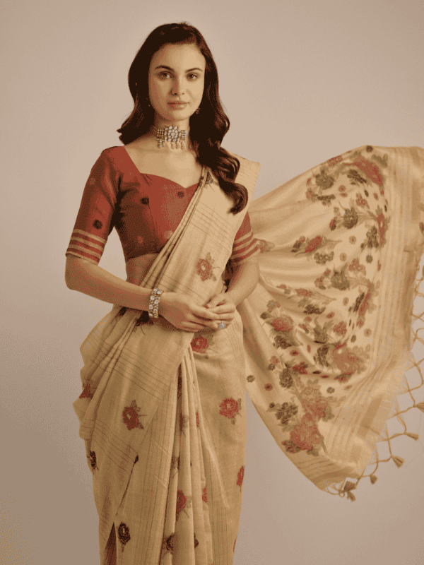 Traditional Muga Cotton saree with vibrant floral motif weaving, elegant buttas, and detailed lining, complemented by a contrast blouse and tassels.