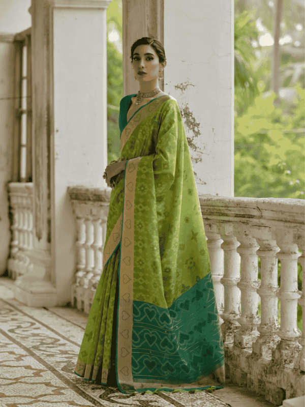 A beautifully woven Soft Desi Raw Silk saree with Pochampally Ikkat design, resham jal weaving, a zari border, and a classic traditional pallu with fancy tassels. Includes a contrast blouse piece.