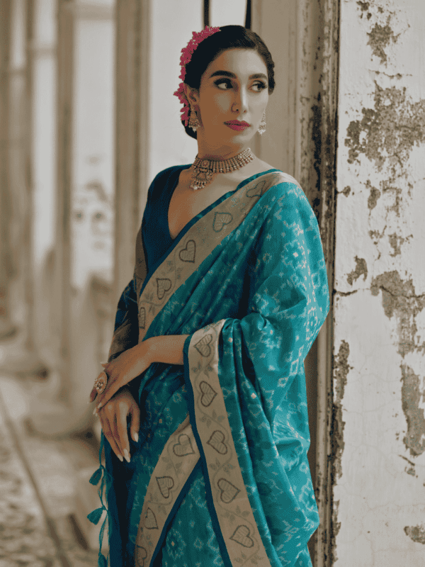 A beautifully woven Soft Desi Raw Silk saree with Pochampally Ikkat design, resham jal weaving, a zari border, and a classic traditional pallu with fancy tassels. Includes a contrast blouse piece.