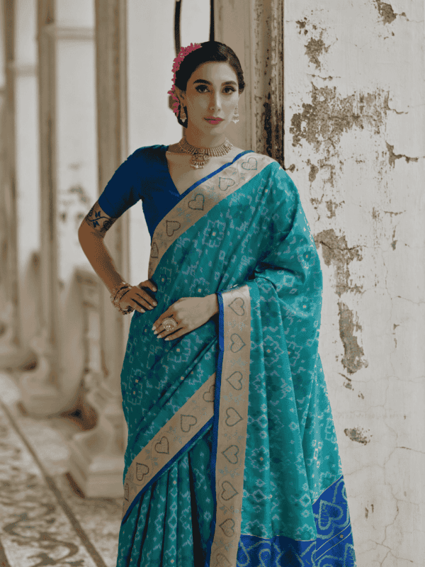 A beautifully woven Soft Desi Raw Silk saree with Pochampally Ikkat design, resham jal weaving, a zari border, and a classic traditional pallu with fancy tassels. Includes a contrast blouse piece.