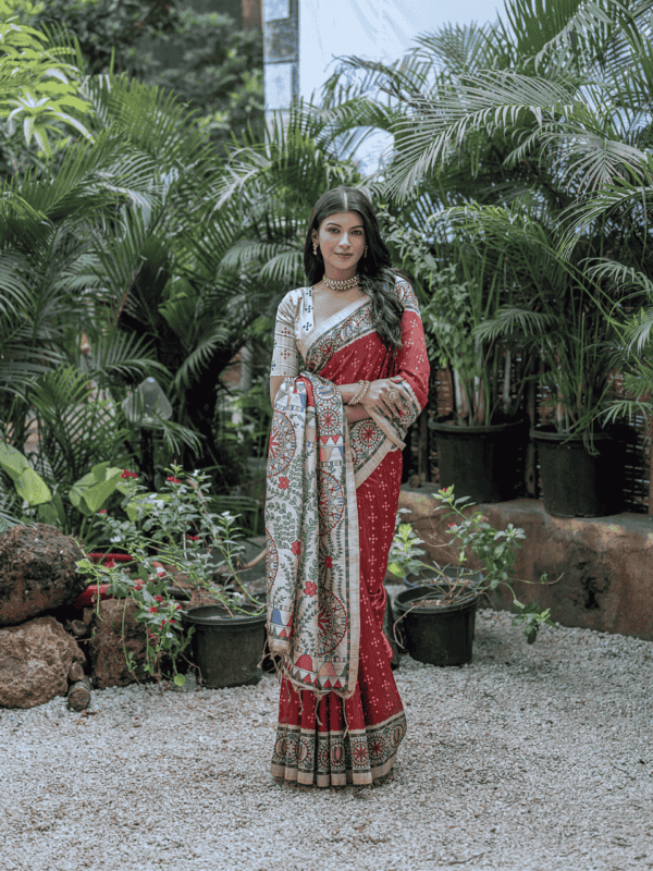 A soft Tussar silk saree adorned with an intricate Madhubani print on the pallu and border, paired with a Bandhani-printed body. Comes with a contrast blouse piece.